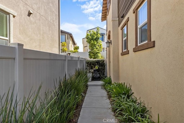 view of side of property featuring fence and stucco siding