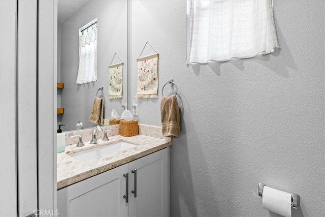 bathroom with a textured wall and vanity