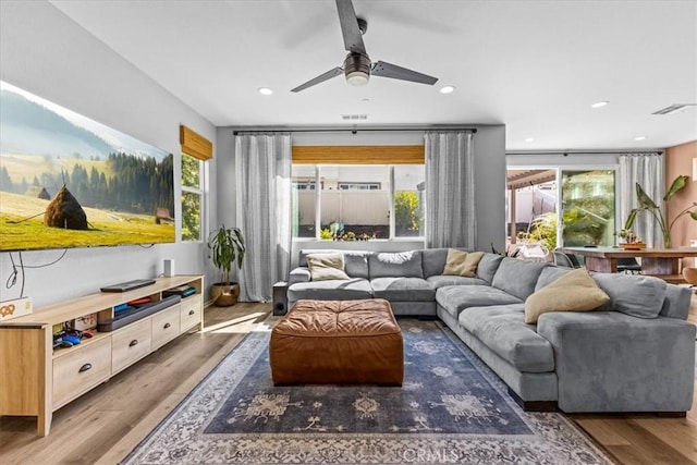 living area with recessed lighting, a healthy amount of sunlight, visible vents, and wood finished floors