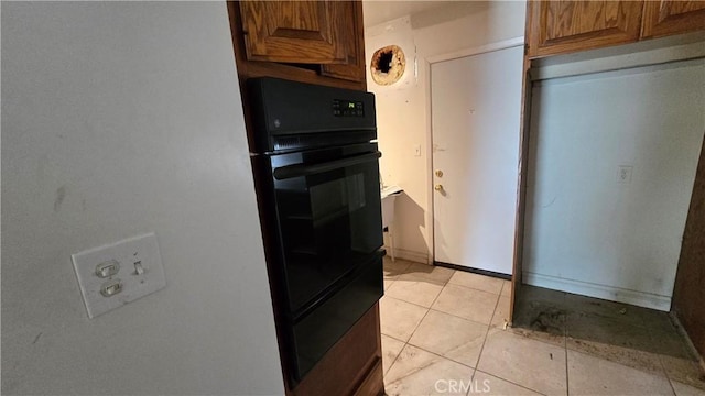 kitchen featuring brown cabinetry and light tile patterned flooring