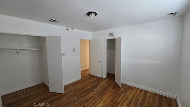 unfurnished bedroom featuring wood finished floors, visible vents, and baseboards