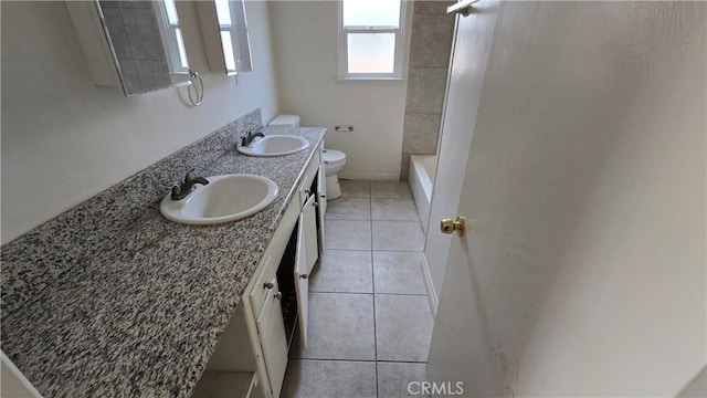 full bath featuring double vanity, tile patterned flooring, a sink, and toilet