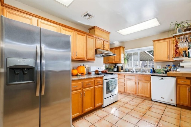 kitchen with white appliances, light tile patterned floors, visible vents, light countertops, and under cabinet range hood