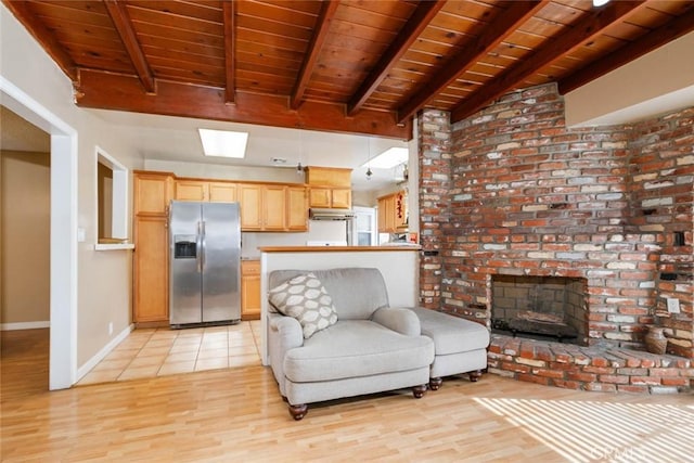 living room with baseboards, wooden ceiling, light wood-style flooring, a brick fireplace, and beam ceiling