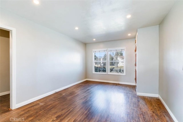 spare room featuring dark wood-style floors, recessed lighting, and baseboards