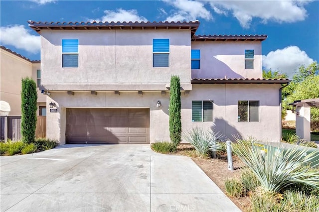 mediterranean / spanish home featuring a garage, concrete driveway, and stucco siding