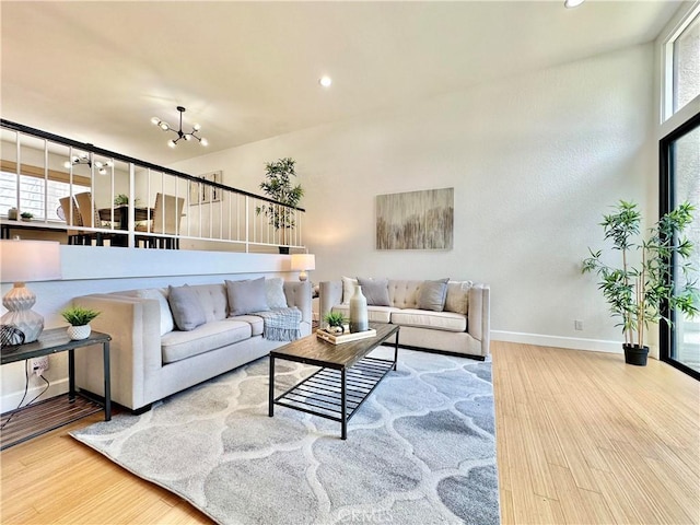 living area featuring baseboards, a chandelier, wood finished floors, and recessed lighting