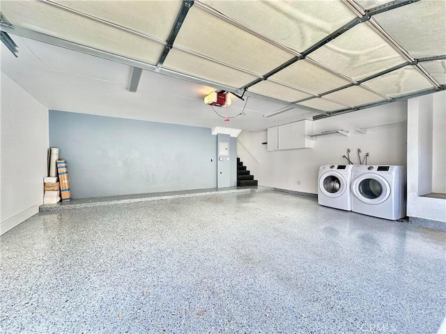 garage with baseboards, washing machine and dryer, and a garage door opener