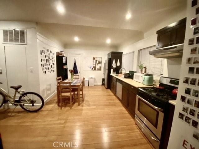 1238 W 35th St, Los Angeles, CA 90007 - kitchen with stainless steel appliances, under cabinet range hood, light wood-style floors, light countertops, and recessed lighting