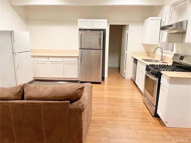 1238 W 35th St, Los Angeles, CA 90007 - kitchen featuring appliances with stainless steel finishes, a sink, under cabinet range hood, light countertops, and light wood-style flooring