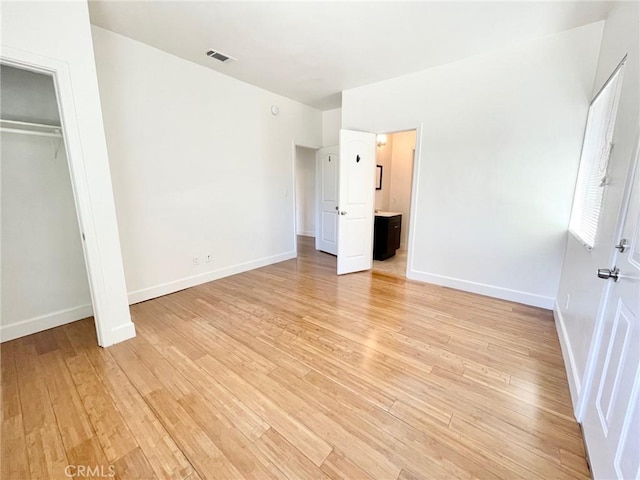 unfurnished bedroom with a closet, baseboards, visible vents, and light wood finished floors