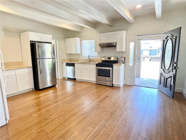 1238 W 35th St, Los Angeles, CA 90007 - kitchen featuring appliances with stainless steel finishes, beam ceiling, plenty of natural light, white cabinetry, and light wood finished floors