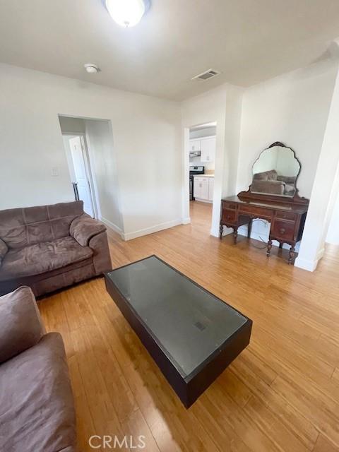 1238 W 35th St, Los Angeles, CA 90007 - living area featuring light wood-style floors and baseboards