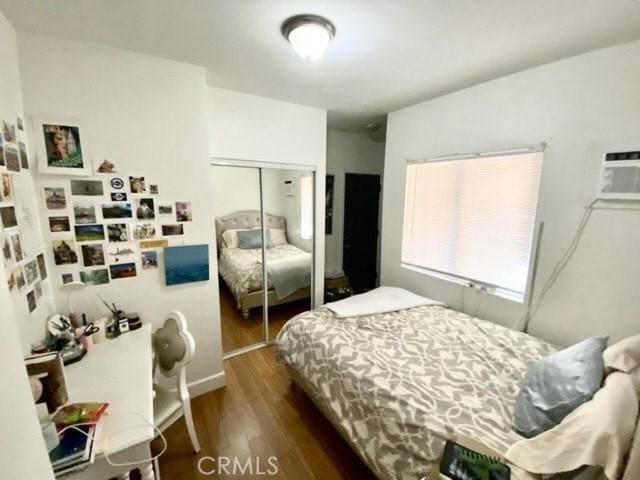 bedroom with wood finished floors and a closet