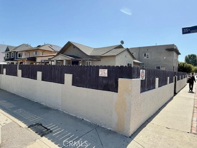 view of home's exterior with a fenced front yard and a residential view