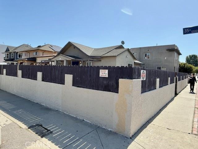 1238 W 35th St, Los Angeles, CA 90007 - view of property exterior featuring a fenced front yard, a residential view, and stucco siding