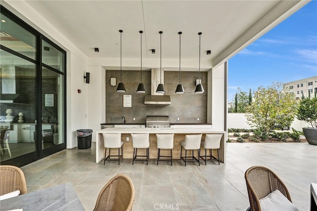 1155 Poppy Ct, Montebello, CA 90640 - bar area featuring wall chimney range hood, hanging light fixtures, expansive windows, and stone tile floors
