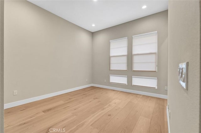 spare room with light wood finished floors, baseboards, and recessed lighting