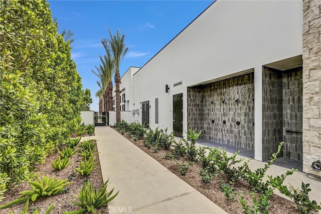 view of property exterior with a gate and stucco siding