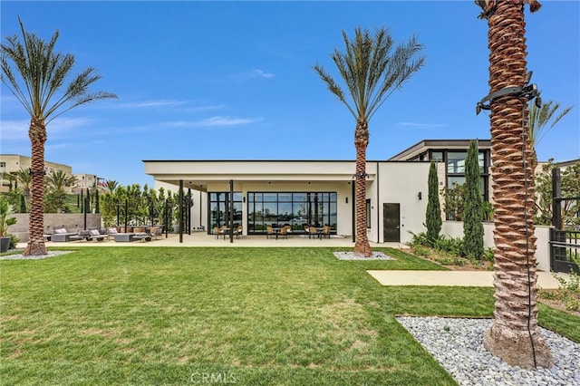 view of community with a yard, an outdoor living space, and a patio