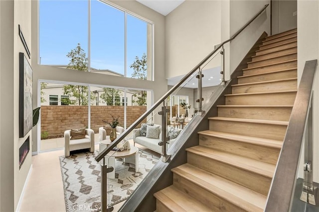 stairs featuring plenty of natural light and a towering ceiling