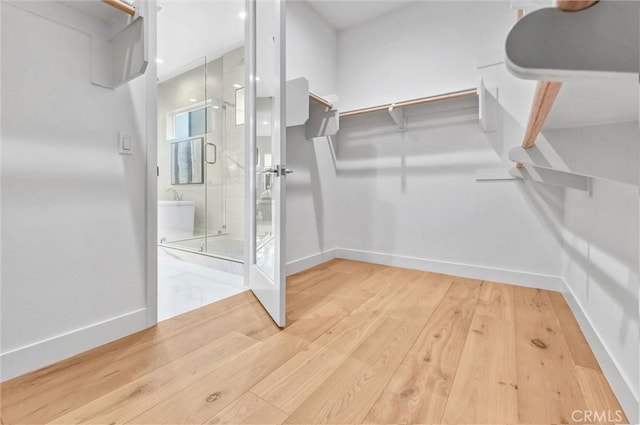 walk in closet with wood finished floors