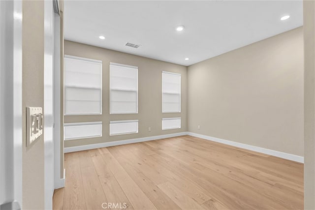 empty room with recessed lighting, light wood-style flooring, and baseboards