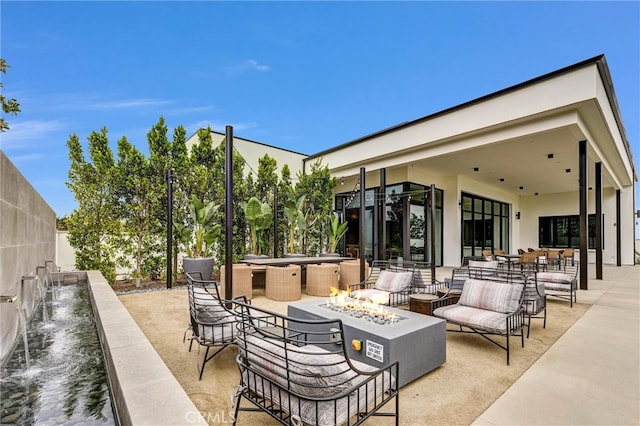 view of patio / terrace featuring an outdoor living space with a fire pit and fence