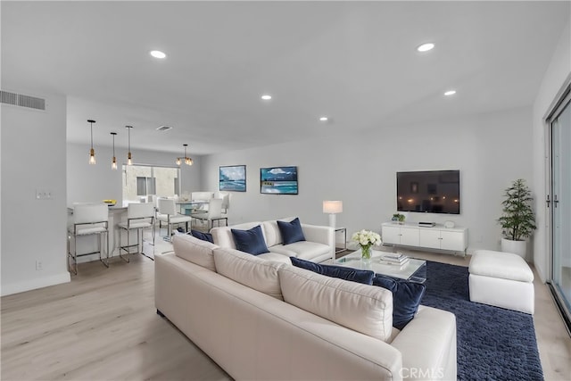 living area featuring light wood-style flooring, visible vents, and recessed lighting