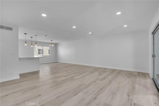 unfurnished living room featuring light wood-style flooring, visible vents, baseboards, and recessed lighting