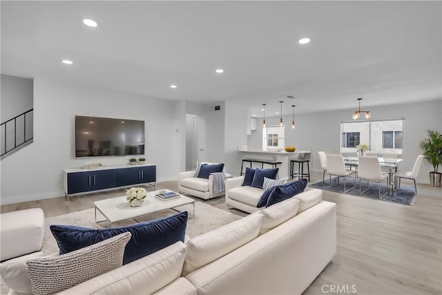 living area with light wood-type flooring, visible vents, baseboards, and recessed lighting