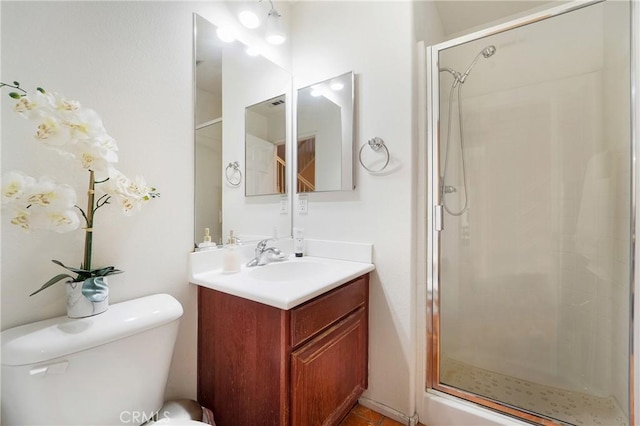 bathroom featuring toilet, a shower stall, and vanity