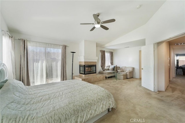 bedroom with ceiling fan, a tile fireplace, carpet flooring, visible vents, and vaulted ceiling