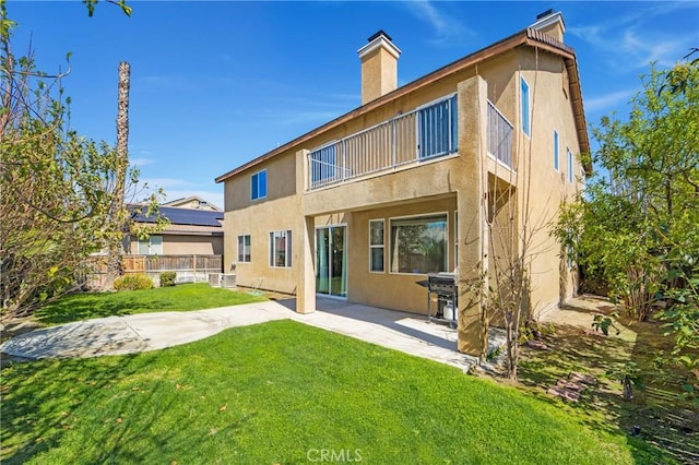 rear view of property with a yard, a patio area, fence, and stucco siding