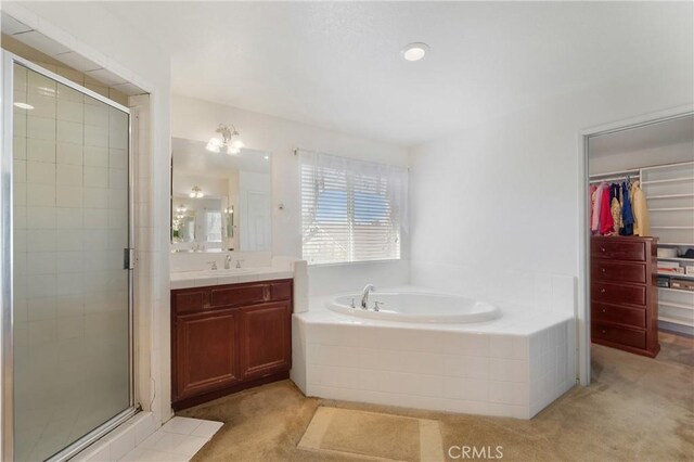 full bath with a garden tub, a spacious closet, and a shower stall