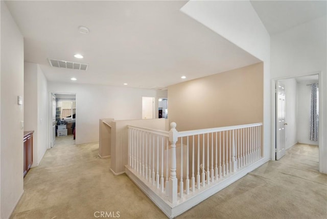 corridor with an upstairs landing, recessed lighting, visible vents, and light colored carpet