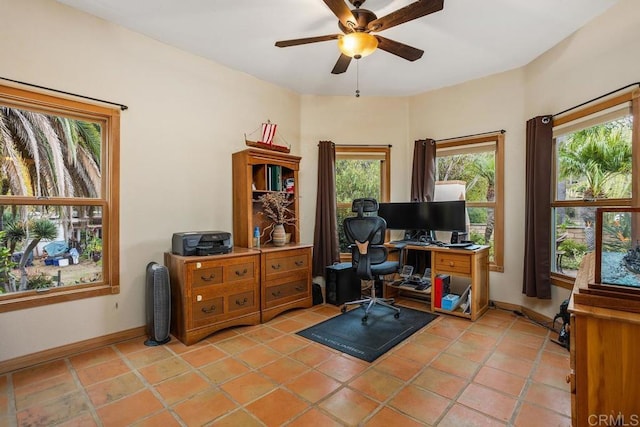 home office featuring ceiling fan, light tile patterned floors, and baseboards