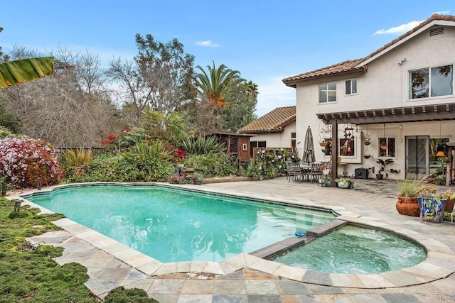 view of pool featuring a pool with connected hot tub and a patio