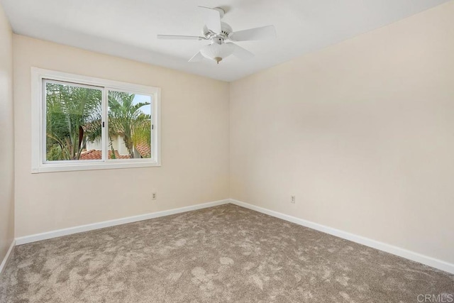 spare room with ceiling fan, carpet, and baseboards