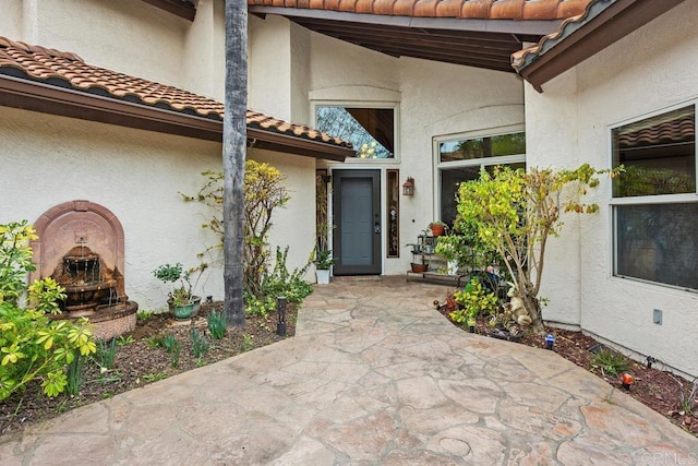 doorway to property with a tiled roof and stucco siding