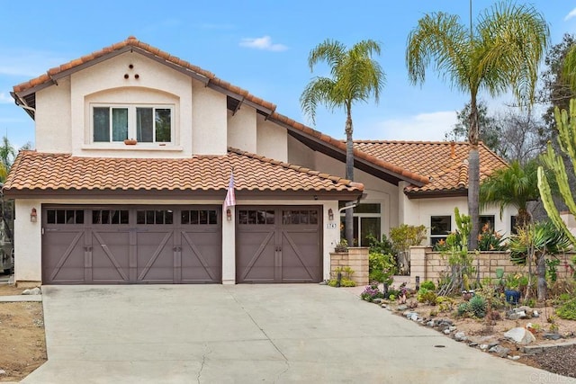 mediterranean / spanish-style home featuring concrete driveway, a tiled roof, and stucco siding