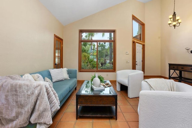 living area with baseboards, high vaulted ceiling, light tile patterned floors, and an inviting chandelier