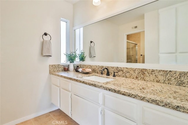 bathroom featuring visible vents, a shower stall, vanity, tile patterned flooring, and baseboards