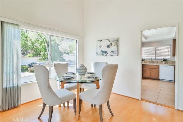 dining area with baseboards and light wood finished floors