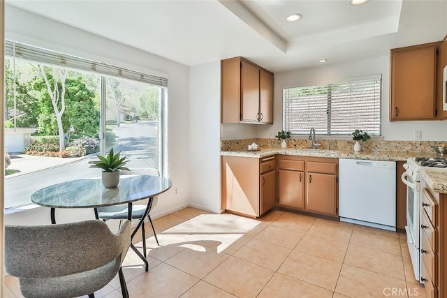 kitchen featuring white appliances, a raised ceiling, light tile patterned flooring, a sink, and recessed lighting