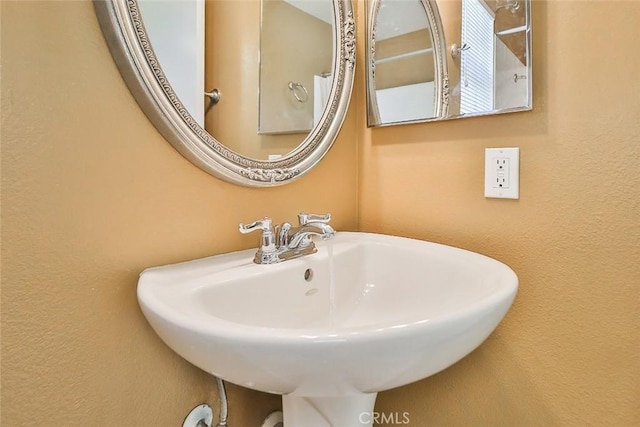 bathroom featuring a textured wall and a sink