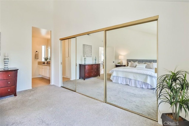 carpeted bedroom featuring a closet, a towering ceiling, and ensuite bathroom