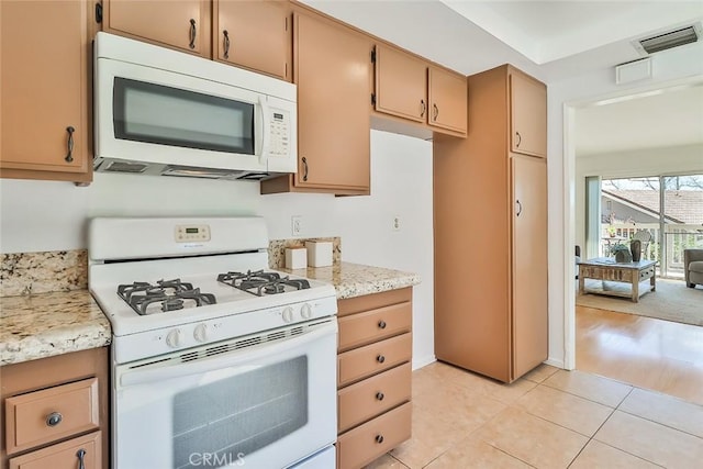 kitchen with white appliances, light tile patterned floors, and visible vents