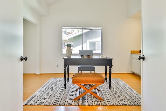 office area with baseboards and wood finished floors