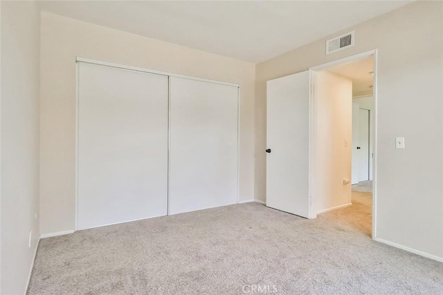 unfurnished bedroom featuring a closet, carpet, and visible vents